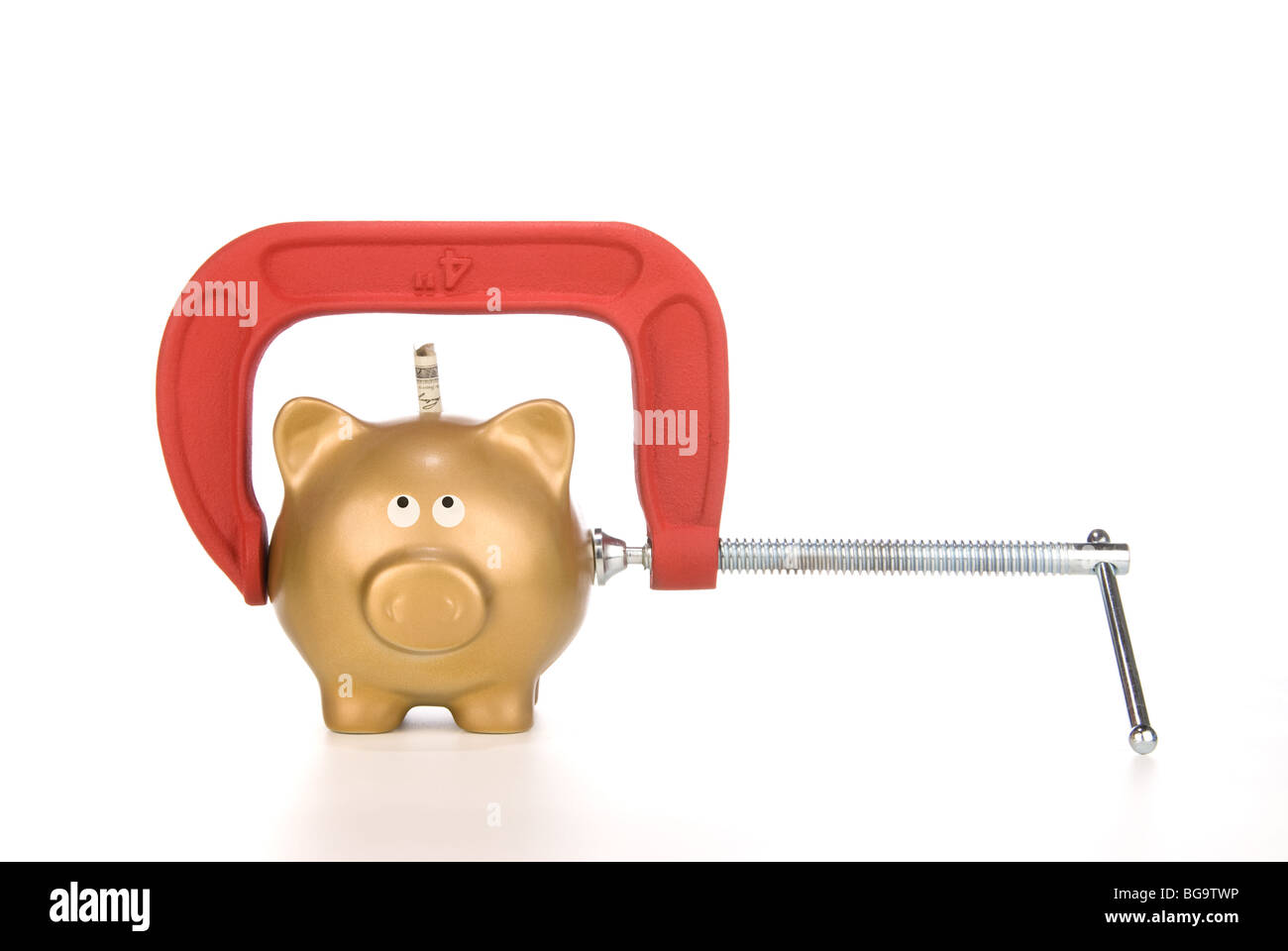 A golden piggy bank is being squeezed for its last dollar. Image can be used for many financial inferences. Stock Photo