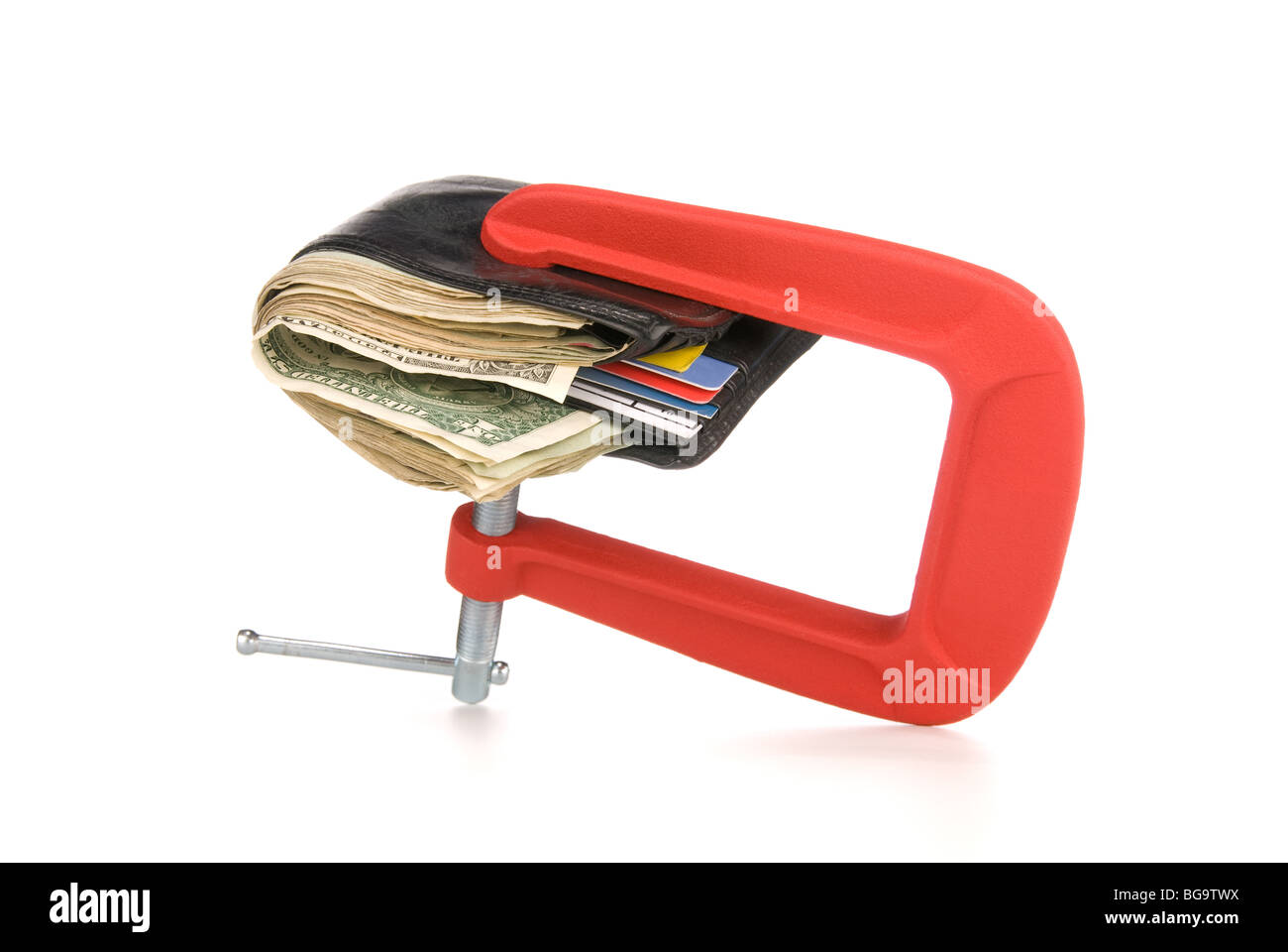 A wallet full of cash is being squeeze and constrained from spending any cash during tough economic times. Stock Photo