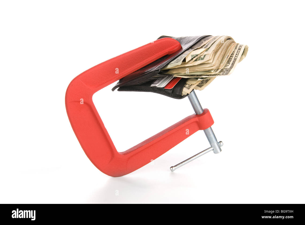 A wallet full of cash is being squeeze and constrained from spending any cash during tough economic times. Stock Photo