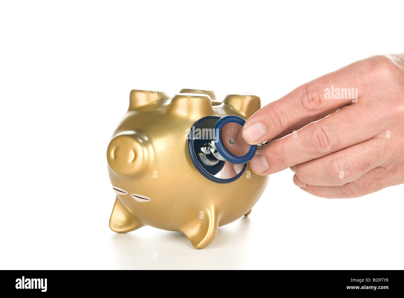 An unconscious piggy bank being examined with a stethoscope for its financial life after a poor economy and recession. Stock Photo