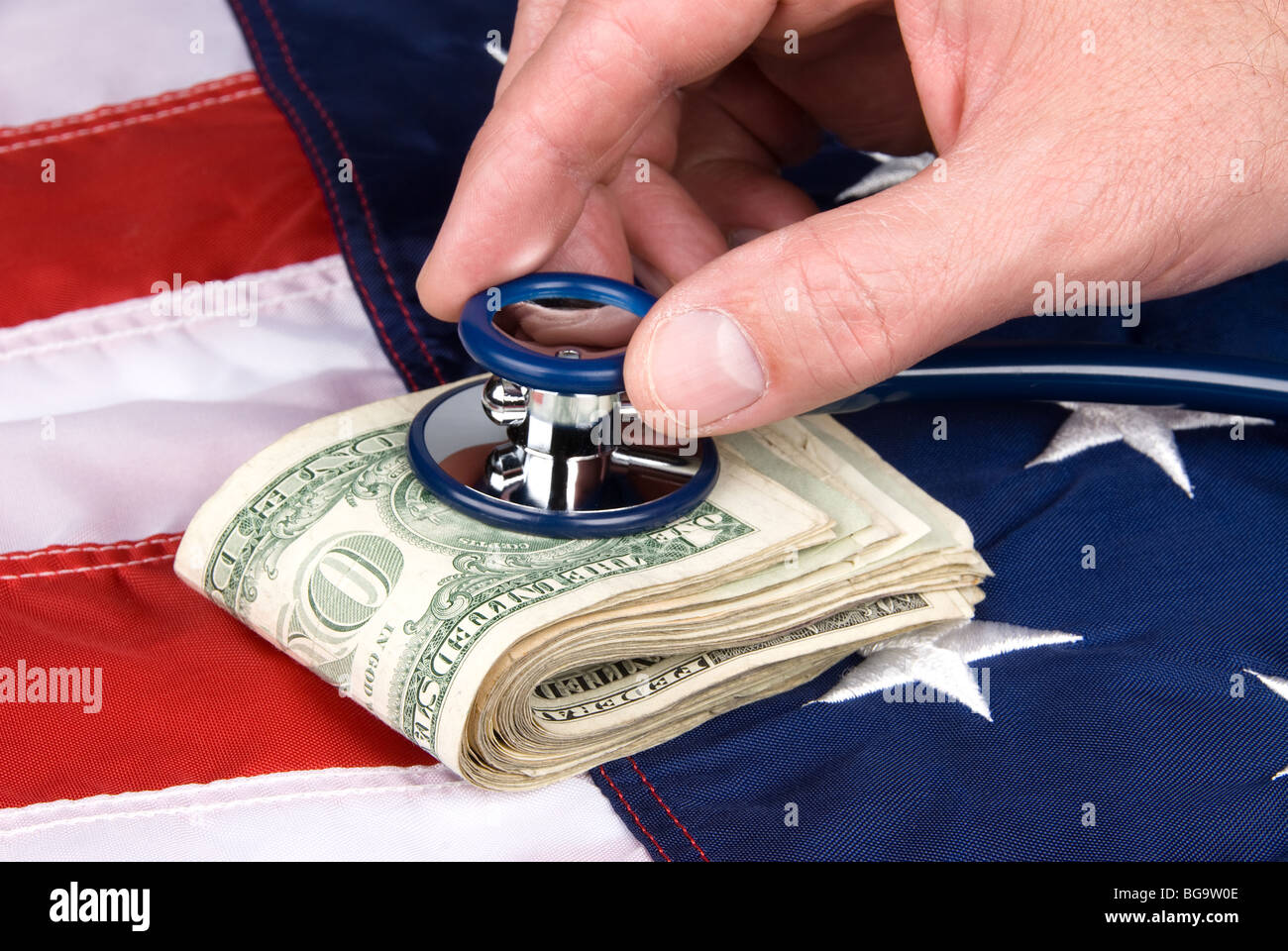 A pile of cash being examined with a stethoscope for signs of life. Image is good for medical or economic inferences. Stock Photo