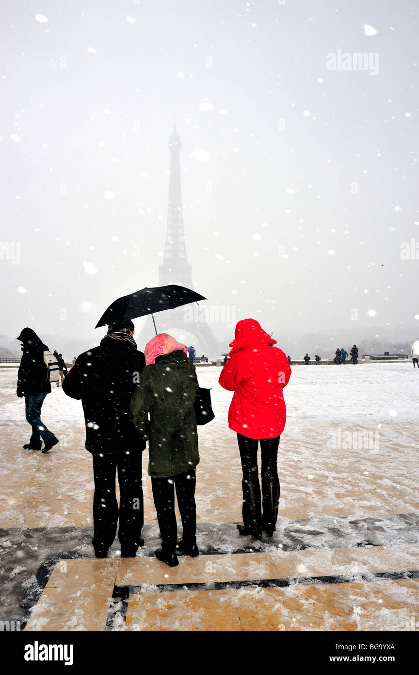 Paris, France, Small Group People, Standing in Snow Storm, group standing from behind, Tourists Holding Umbrella near Eiffel Tower WINTER SCENE Stock Photo