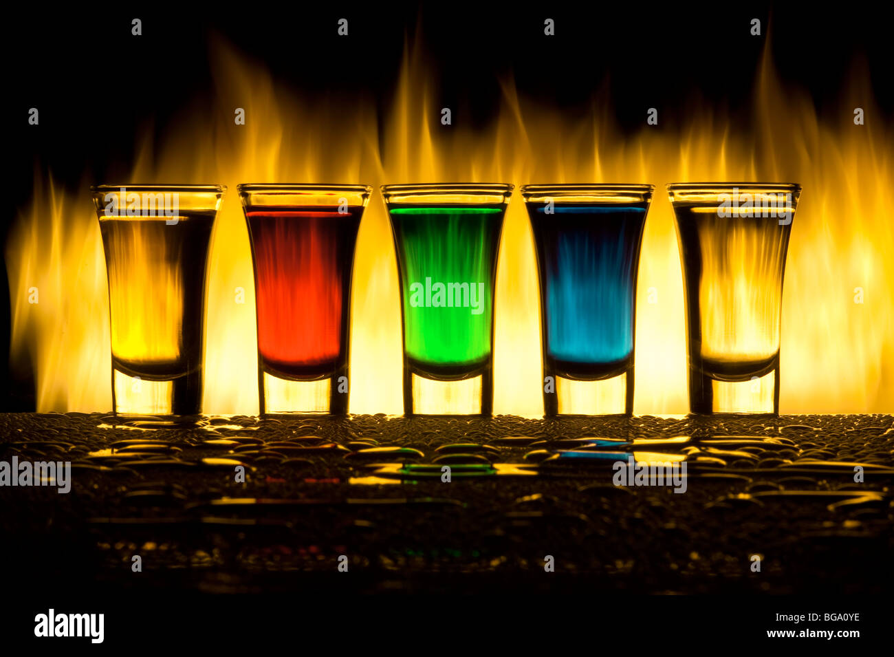 Five colour cocktails against fire with reflexion in water drops Stock Photo