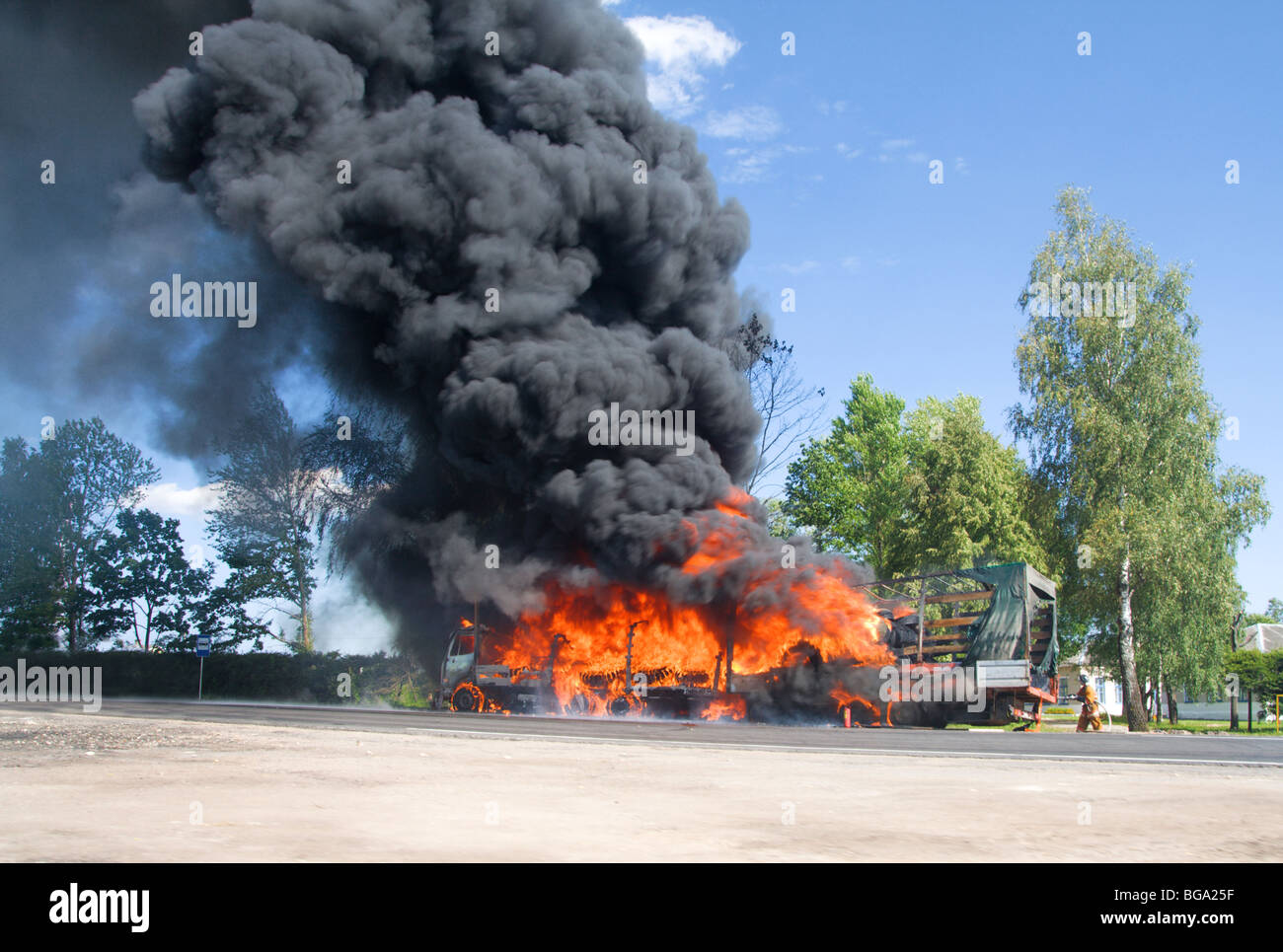 truck in fire with black smoke on the road Stock Photo