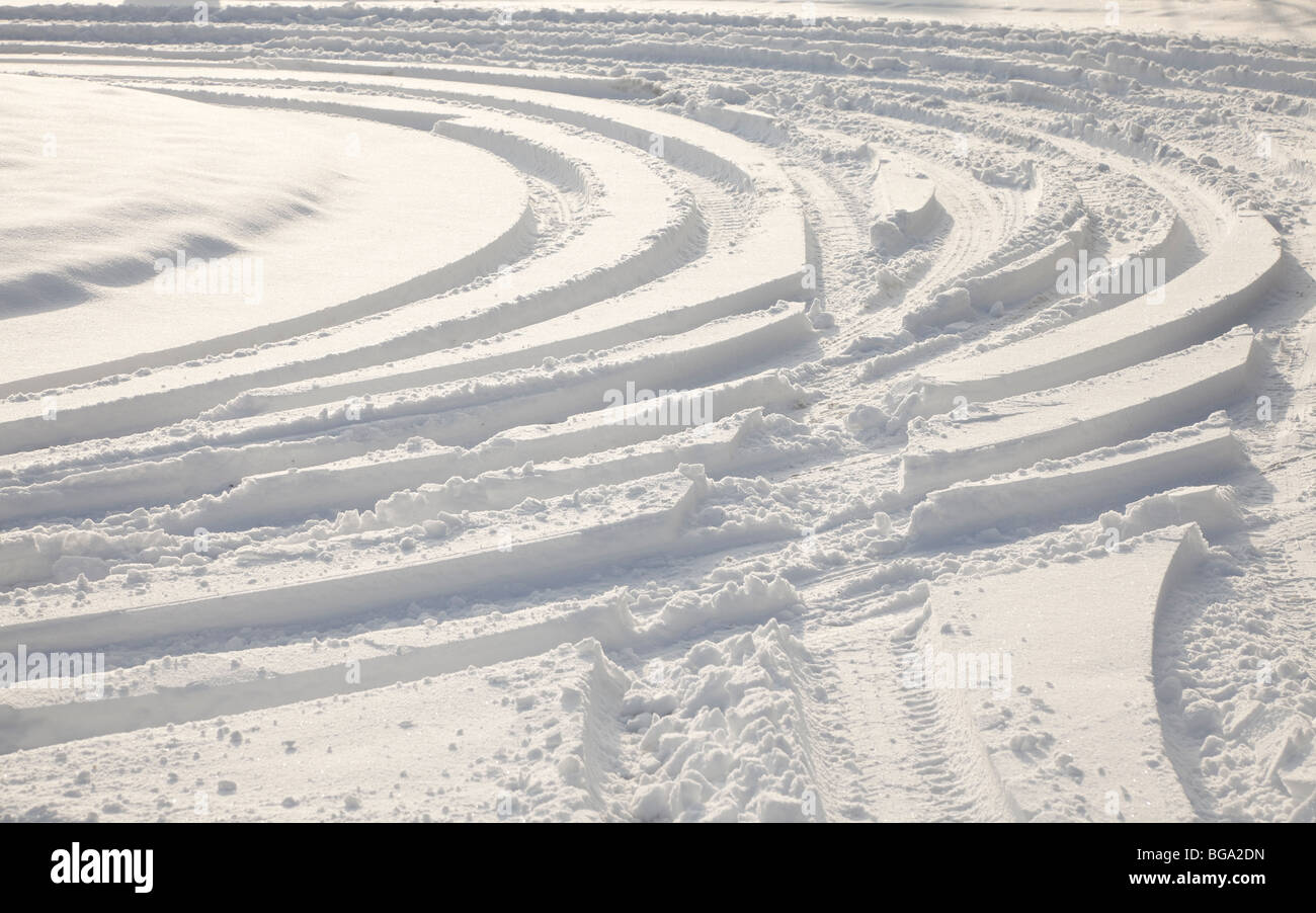 Car tyre tracks in deep snow, winter sun Stock Photo