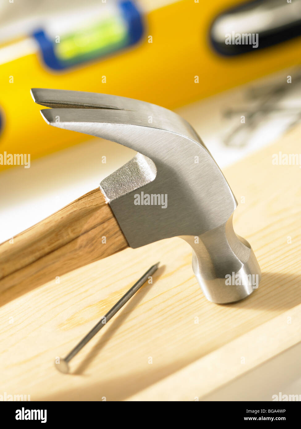 Hammer on wood board with nail and level Stock Photo