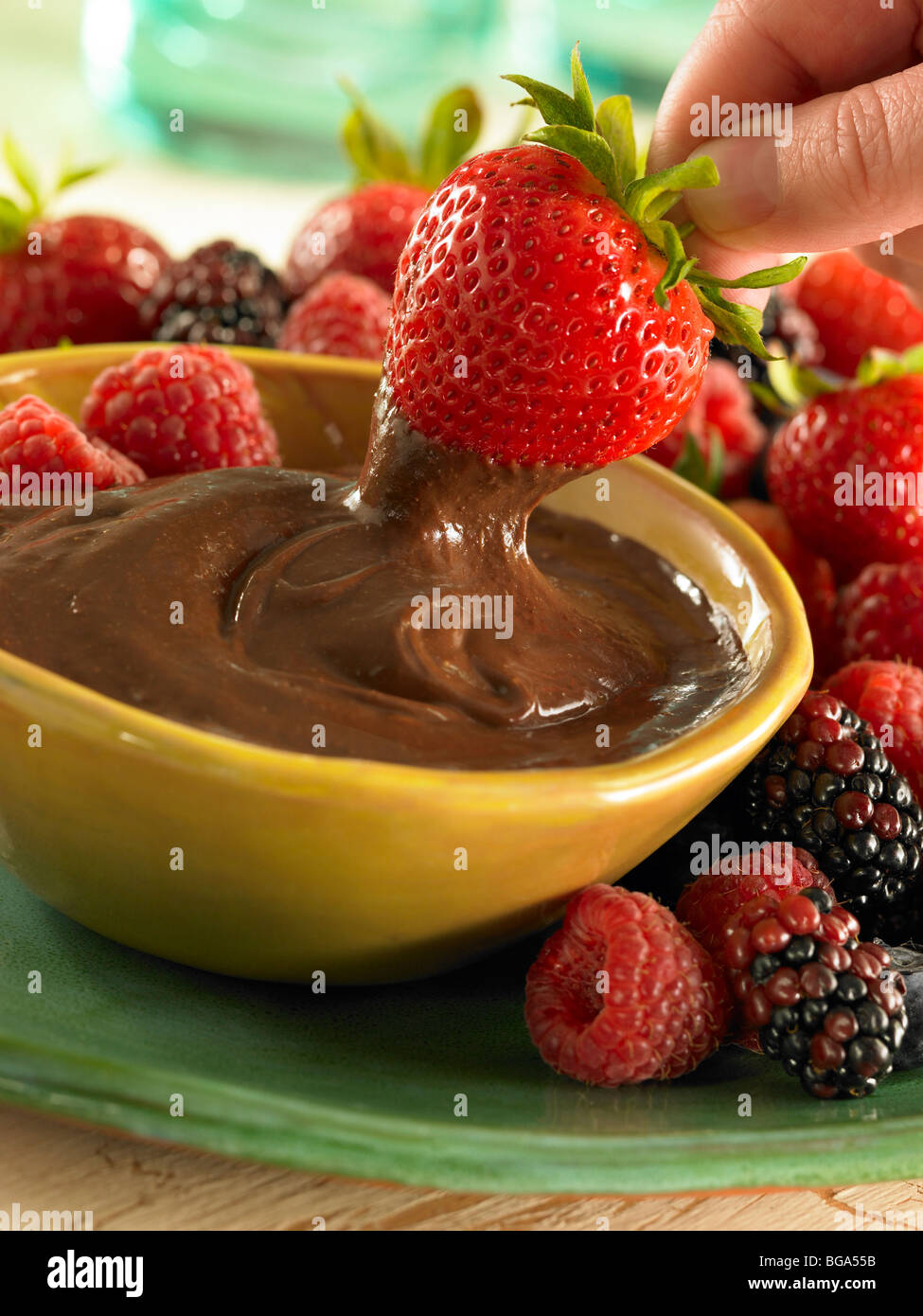 Strawberry dipping in chocolate sauce Stock Photo Alamy