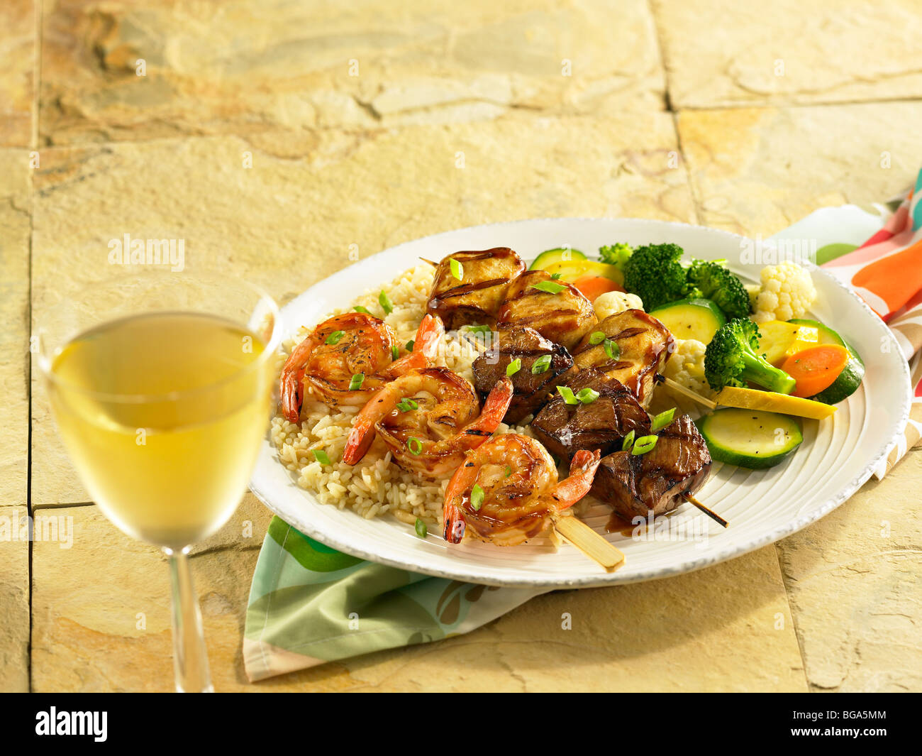 Shrimp, beef and chicken skewers with mixed vegetable on rice Stock Photo