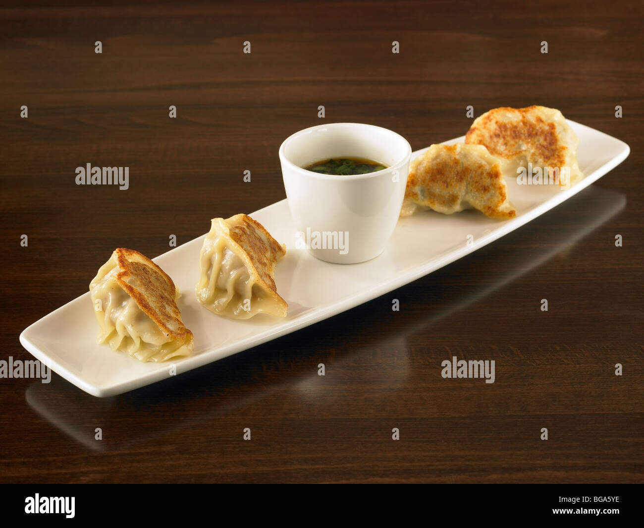 Pan fried dumplings with dipping sauce Stock Photo