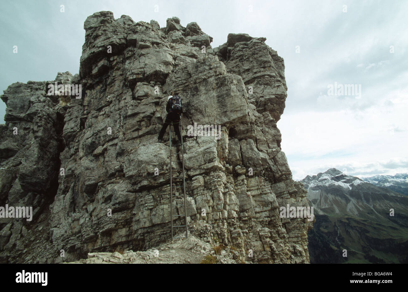 Fixed cable route mountaneer climbing a vertical ledder of the Mindelheimer Klettersteig, Allgäuer Alps, Germany Stock Photo