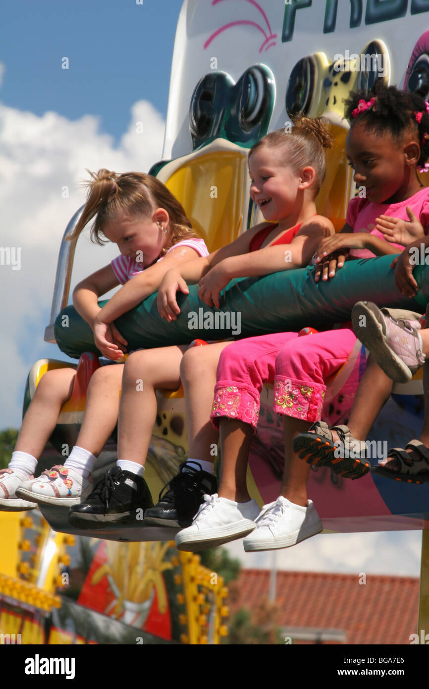 Three Girls on Frog Hopper Carnival Ride. Ohio State Fair. Columbus, Ohio, USA. Caucasian and Afroamerican girls. Stock Photo