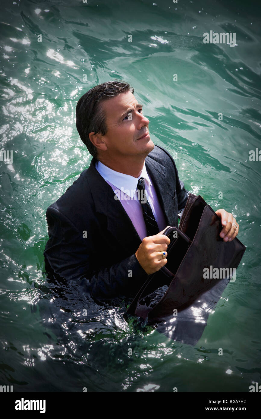 Businessman walking in deep water Stock Photo Alamy