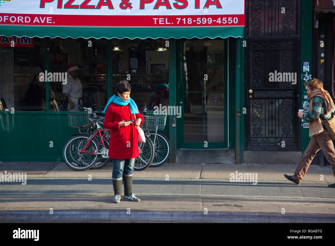 Young woman waiting for the bus in Williamsburg, Brooklyn, New York Stock Photo