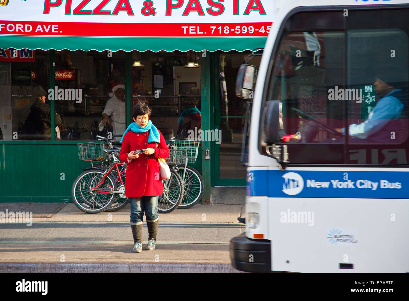 Young woman waiting for the bus in Williamsburg, Brooklyn, New York Stock Photo