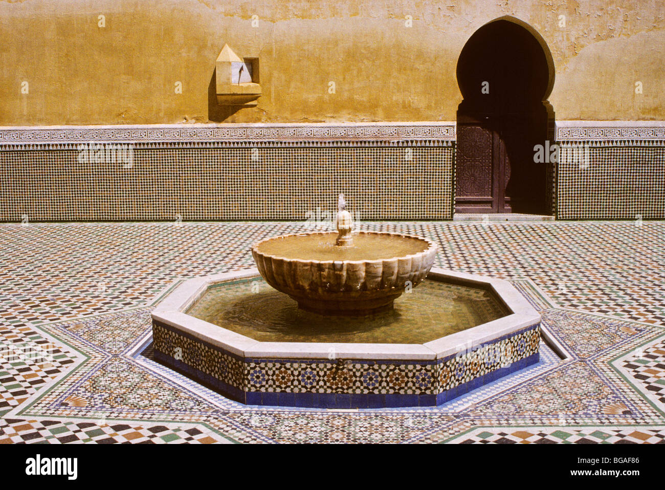 Meknes, Morocco. Courtyard of the Mausoleum of Moulay Ismail, with Sun Dial, Horseshoe Arch Doorway, Fountain. Stock Photo