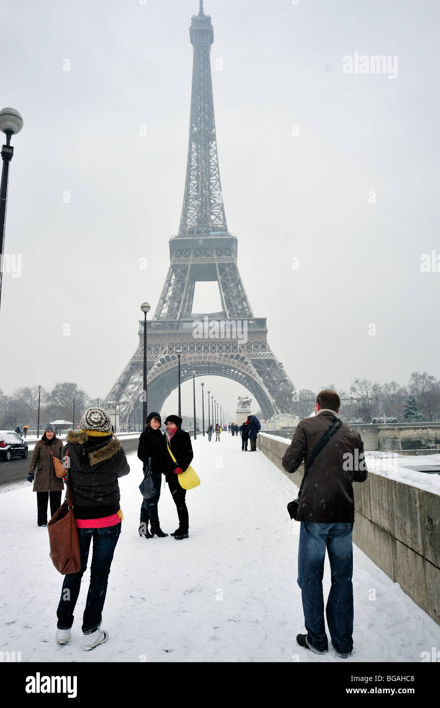 Paris, Street, France, Medium Group of People, Standing, Teen Tourists Visiting Eiffel Tower, in Winter People in Snow Storm, outside , Bridge Stock Photo