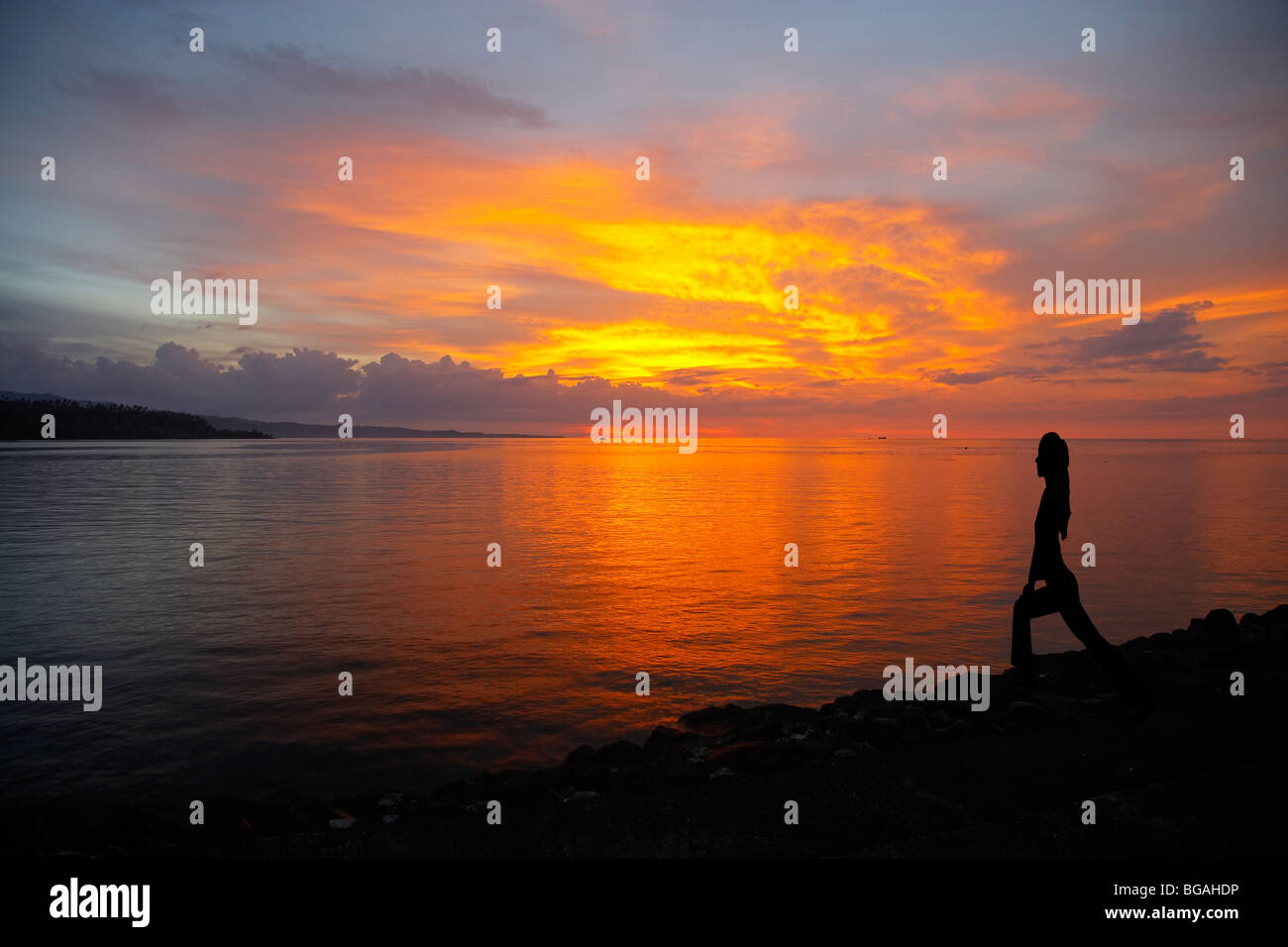 Silhouette of a Woman doing Yoga at Sunset on a beach in North Sulawesi ...