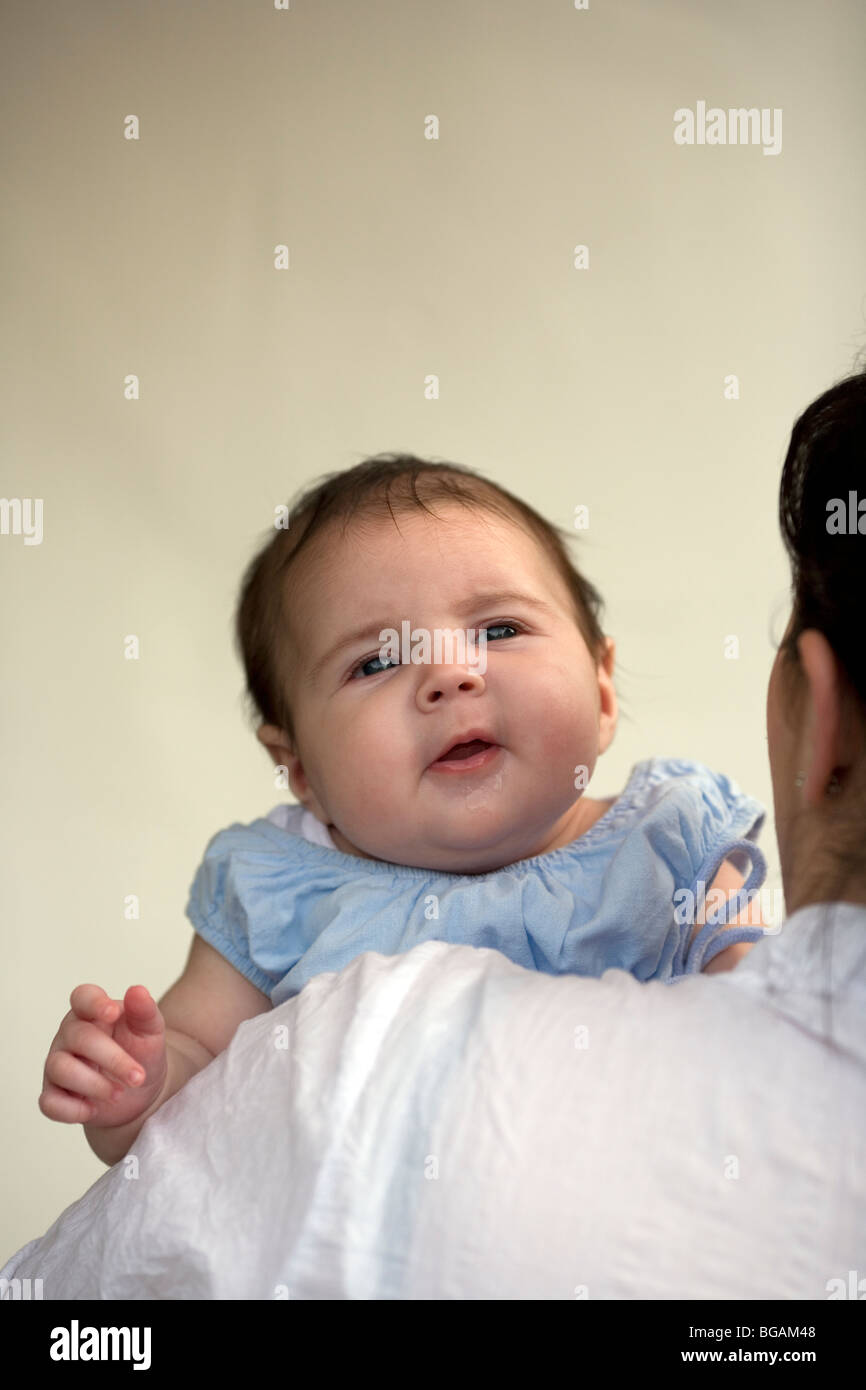 Baby being held looking over mother's shoulder Stock Photo