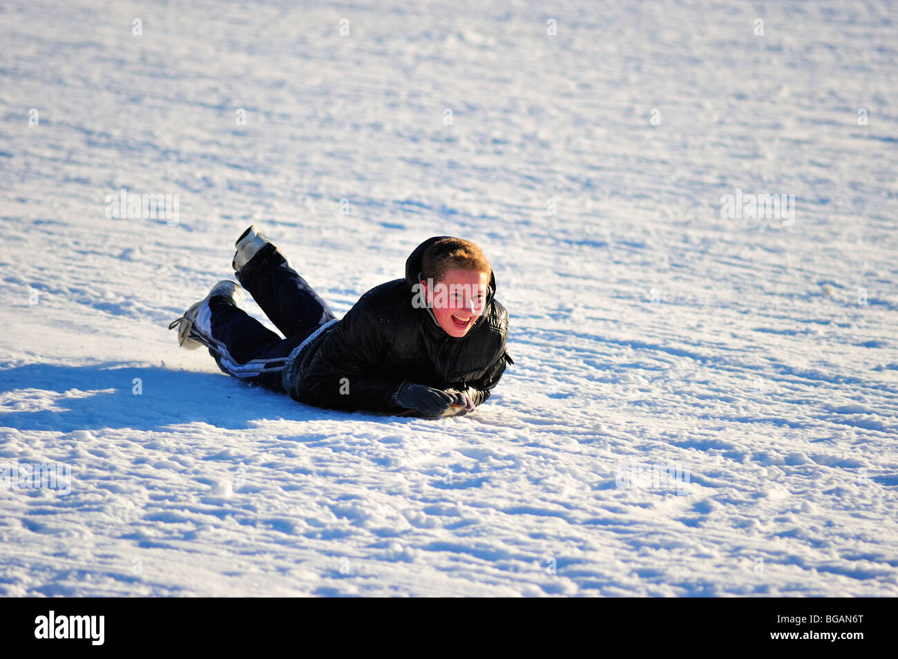 Boy having fun sliding on snow Stock Photo Alamy