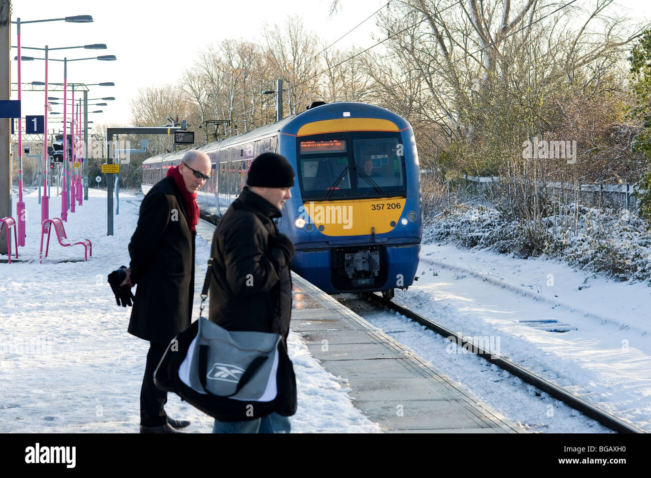 Commuters on a snow covered railway platform as a train comes in..  Photo by Gordon Scammell Stock Photo