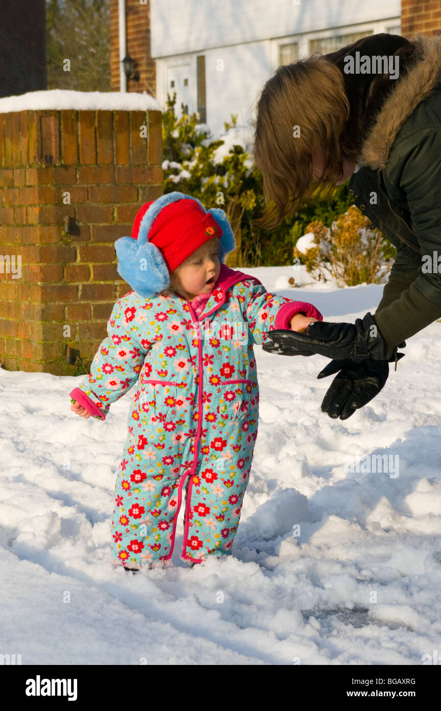 Grandmother Putting On Baby Girls Gloves In The Snow Stock Photo - Alamy