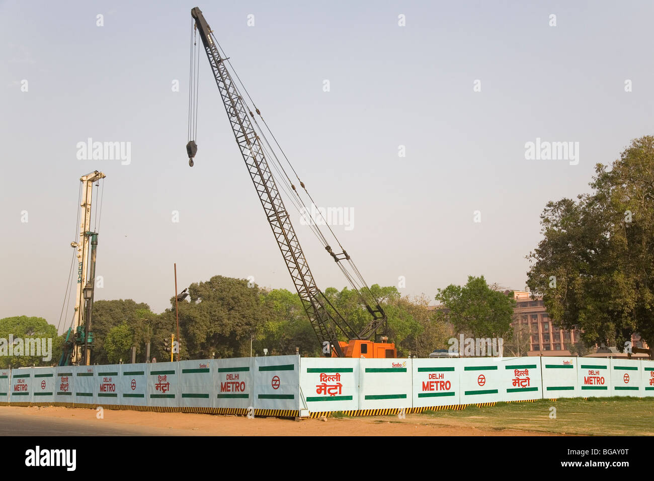 A crane stands behind barriers as building work is undertaken on the Delhi Metro in New Delhi, India. Stock Photo