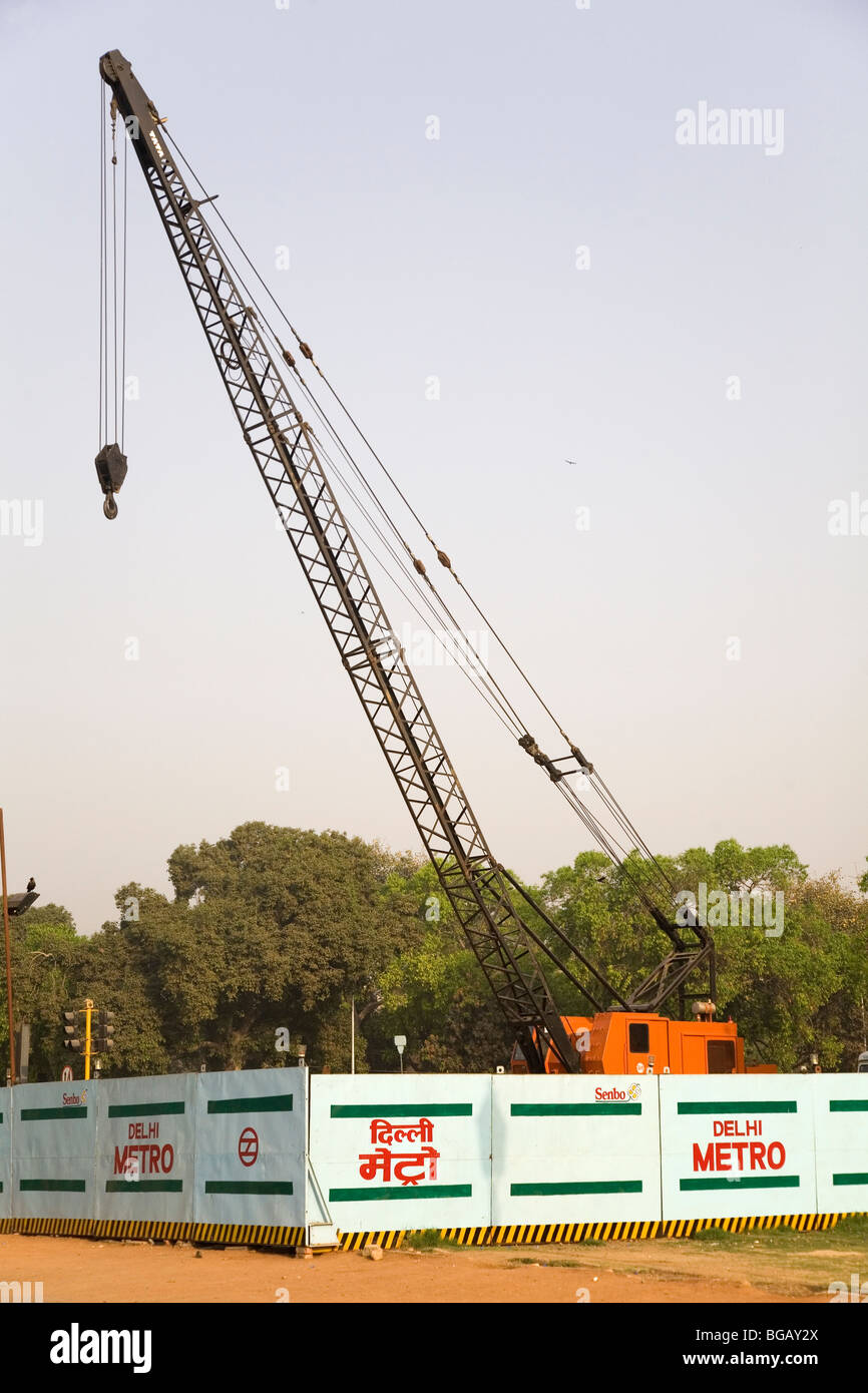 A crane stands behind barriers as building work is undertaken on the Delhi Metro in New Delhi, India. Stock Photo