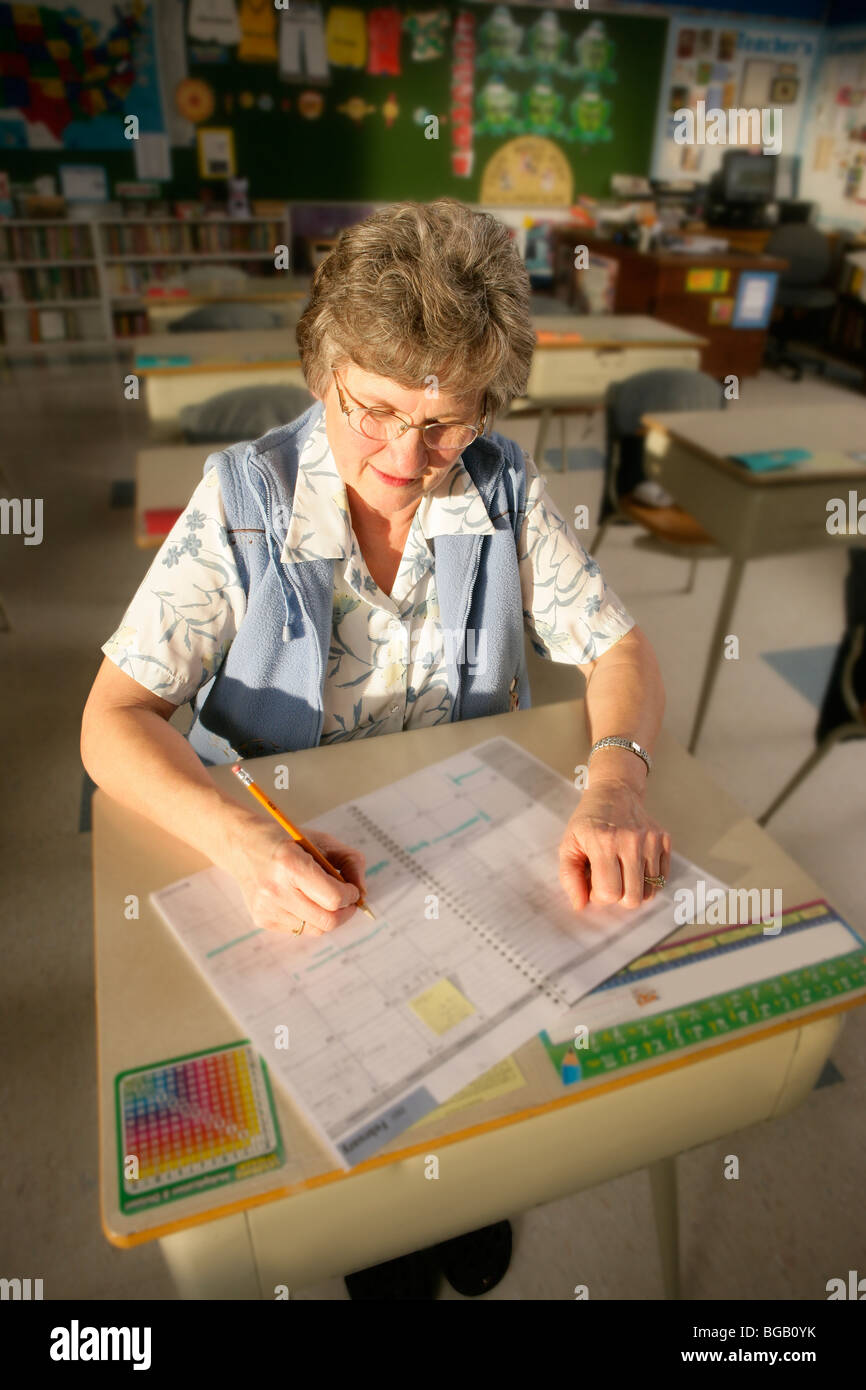 Teacher; Teacher Sitting At A Desk Stock Photo - Alamy