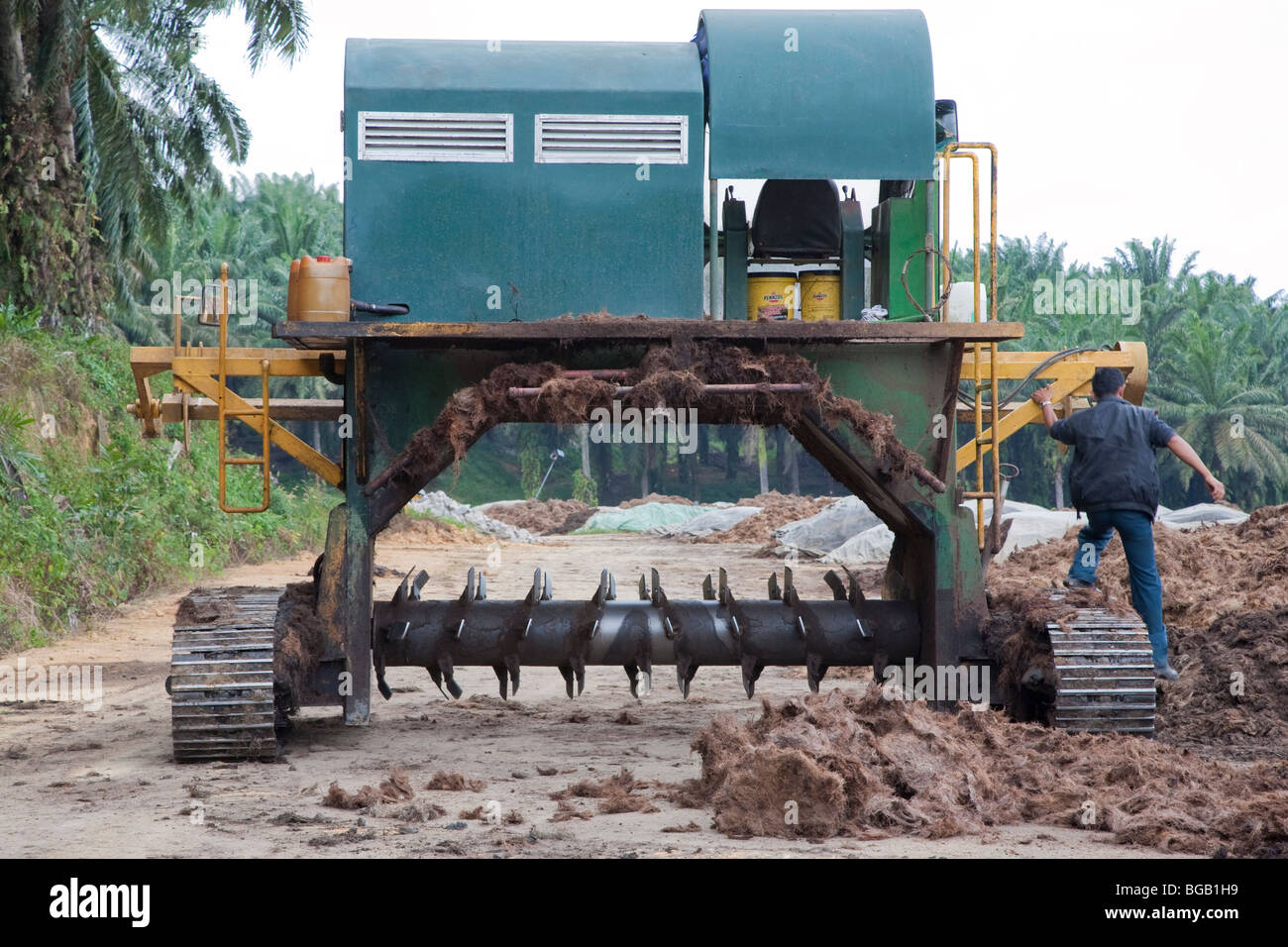 This machine is used to aerate the compost piles by turning them over. Sindora Palm Oil Plantation Stock Photo