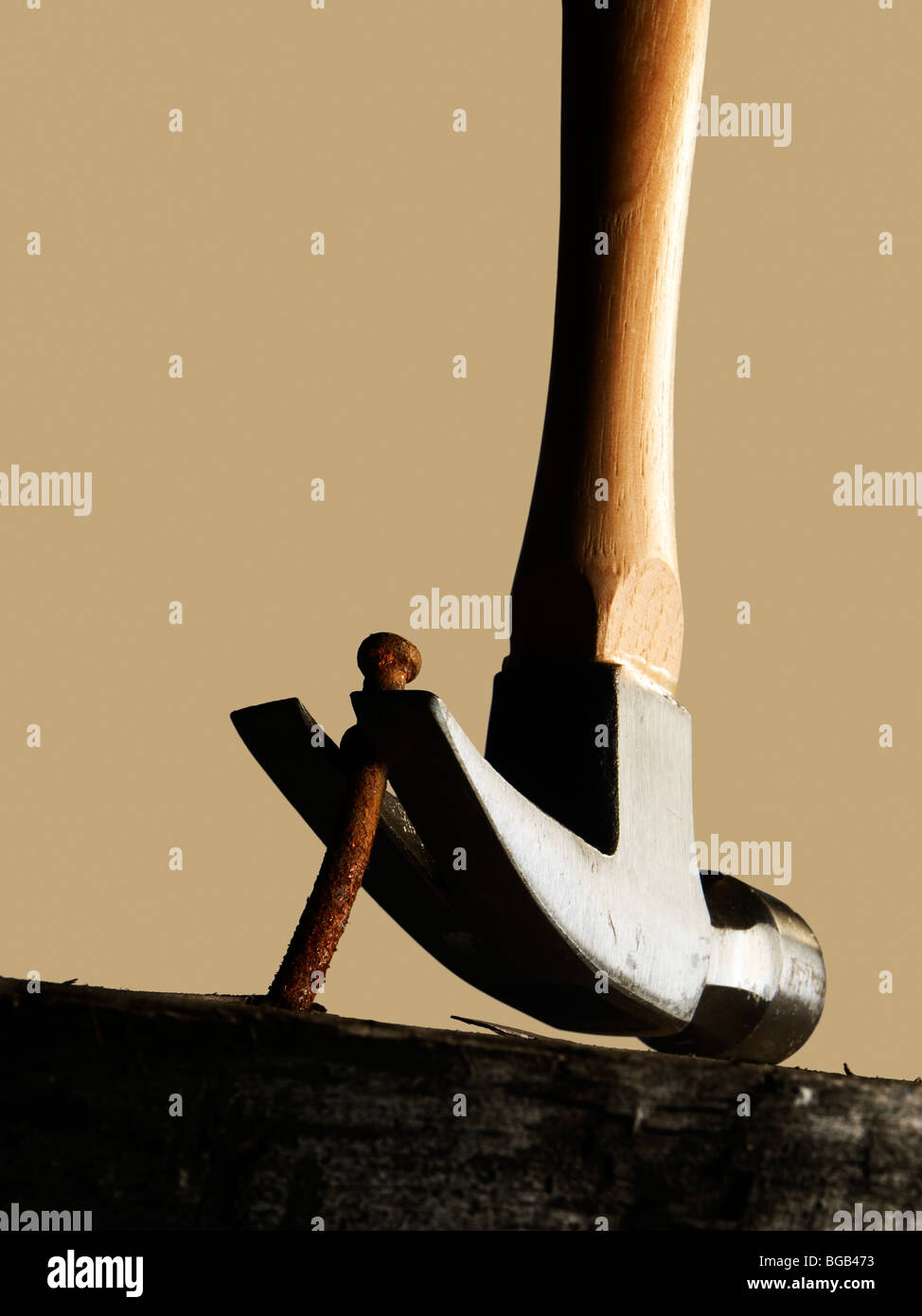 Hammer Removing A Nail From A Wooden Surface Stock Photo