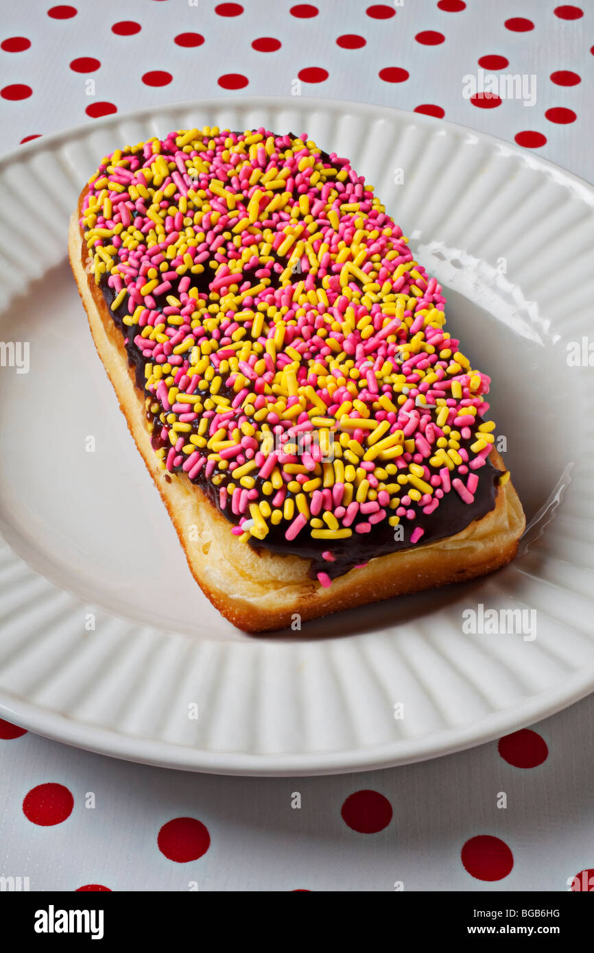 Donut with sprinkles on white plate Stock Photo