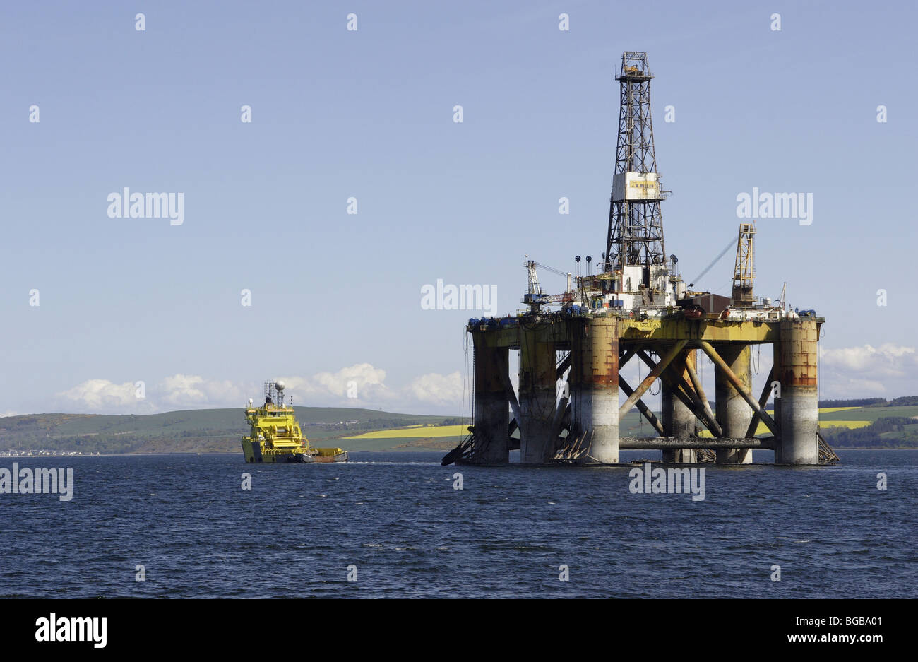 Scotland, Invergordon.  Oil rig platform being pulled out to sea by tug vessel. Stock Photo