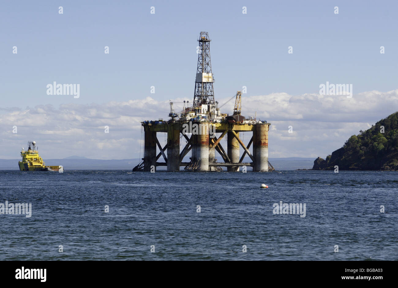Scotland, Oil Rig Platform being pulled out to sea by tug vessel. Stock Photo