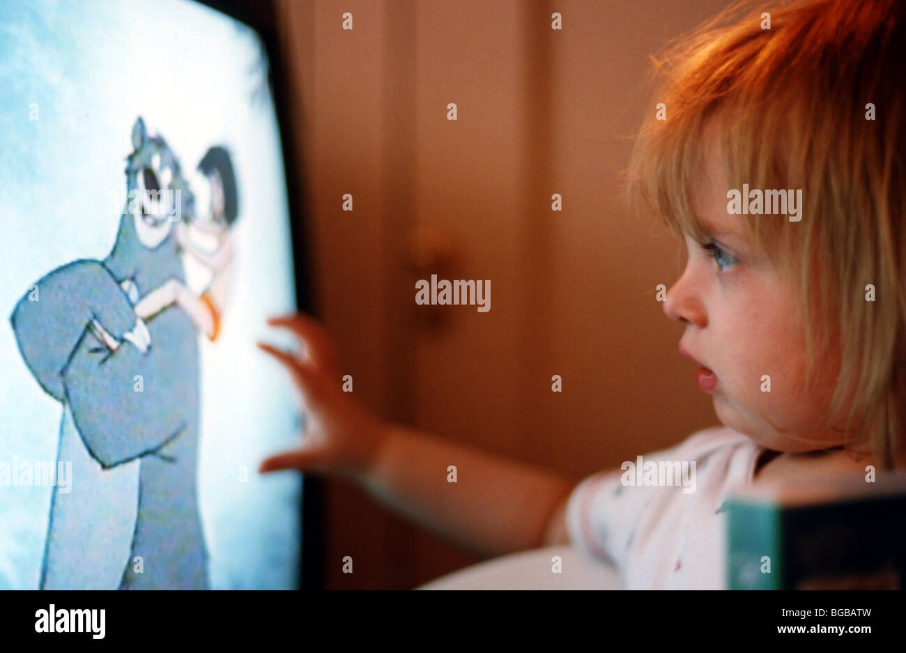 Photograph of child watching tv television kids cartoons looking Stock Photo