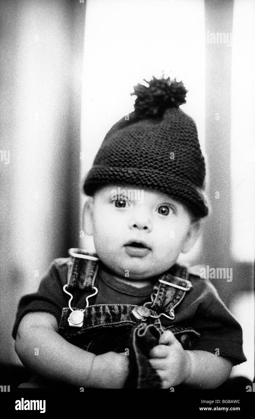 Photograph of bobble hat young child wide eyed alert baby funny Stock Photo