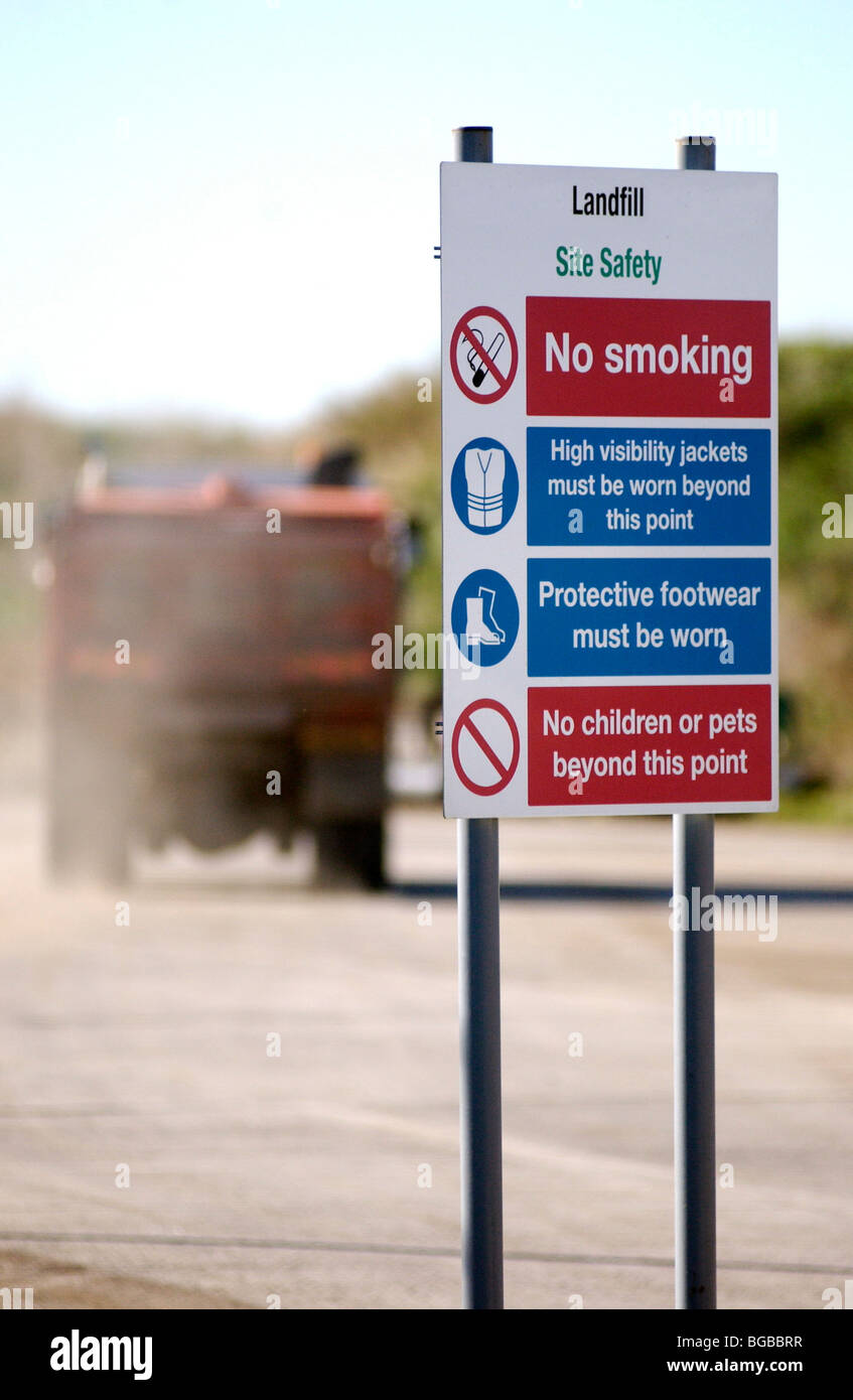 Royalty free photograph showing sign at the entrance to landfill site with dumping truck/lorry driving into the site UK Stock Photo