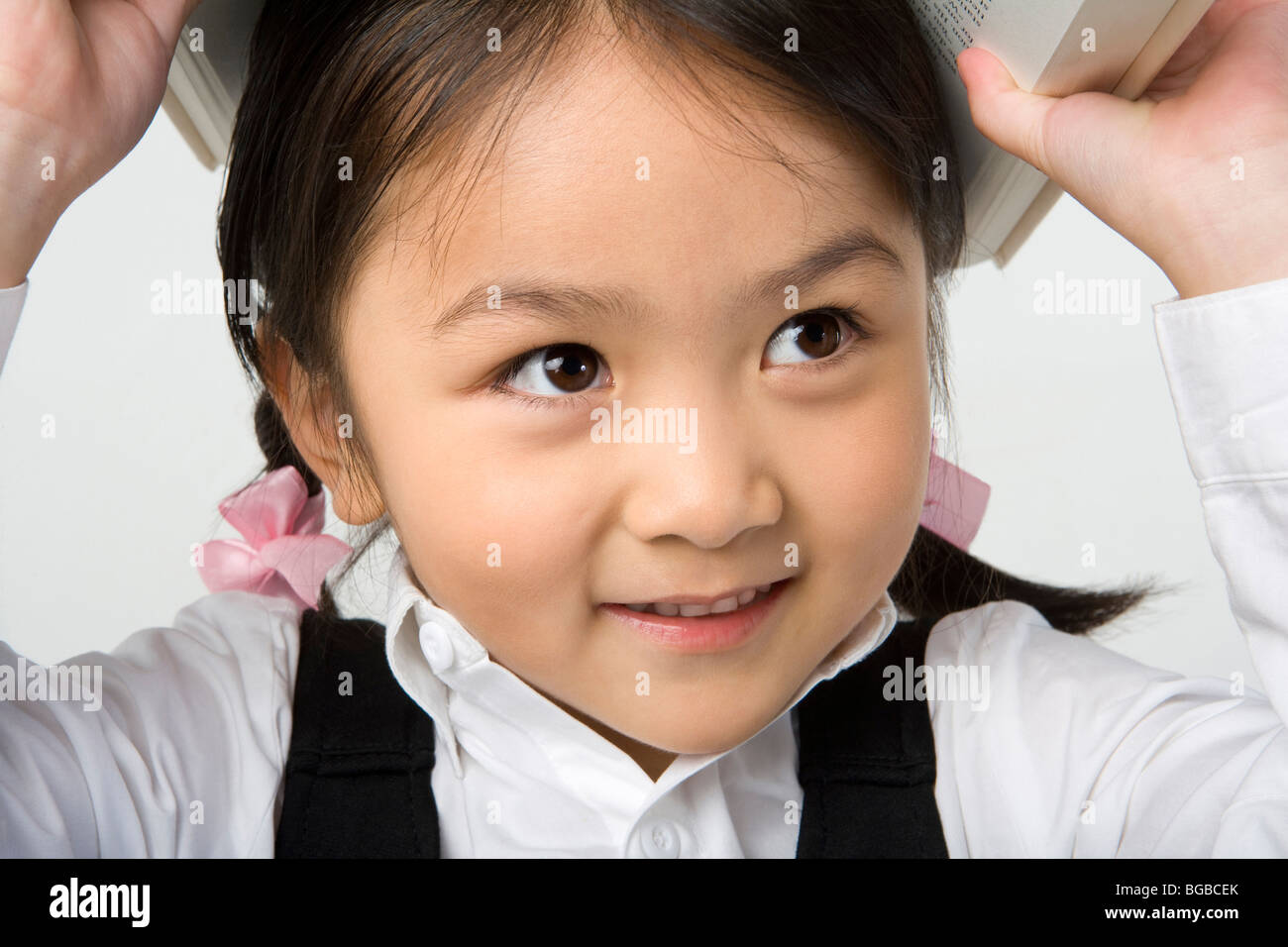 Little girl has a book on her head Stock Photo - Alamy