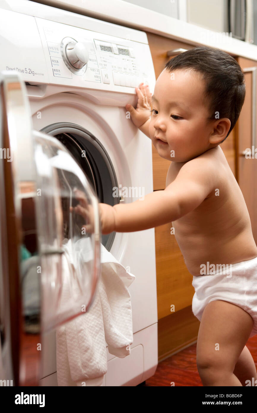 Infant with washing machine Stock Photo Alamy