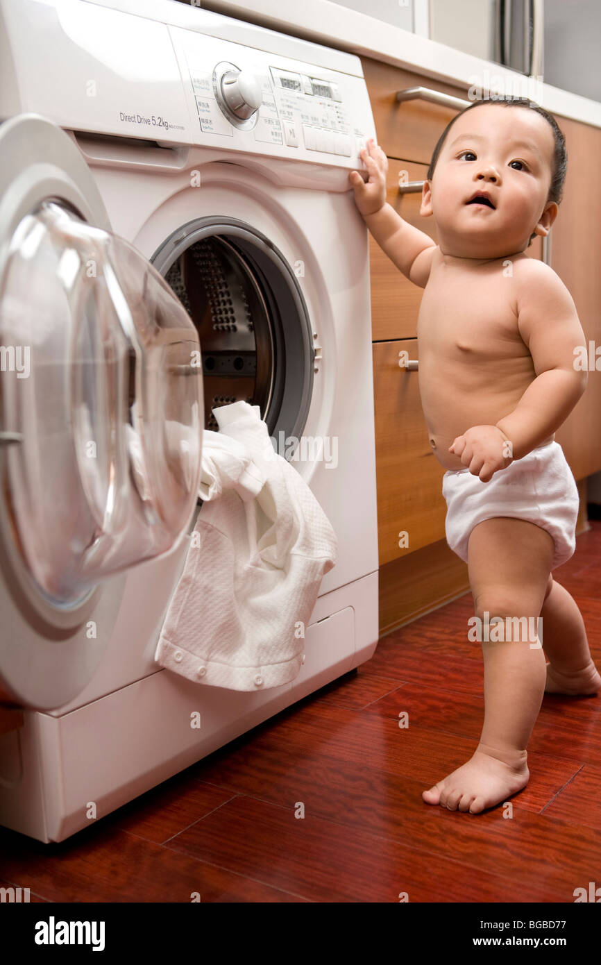 Infant with washing machine Stock Photo Alamy
