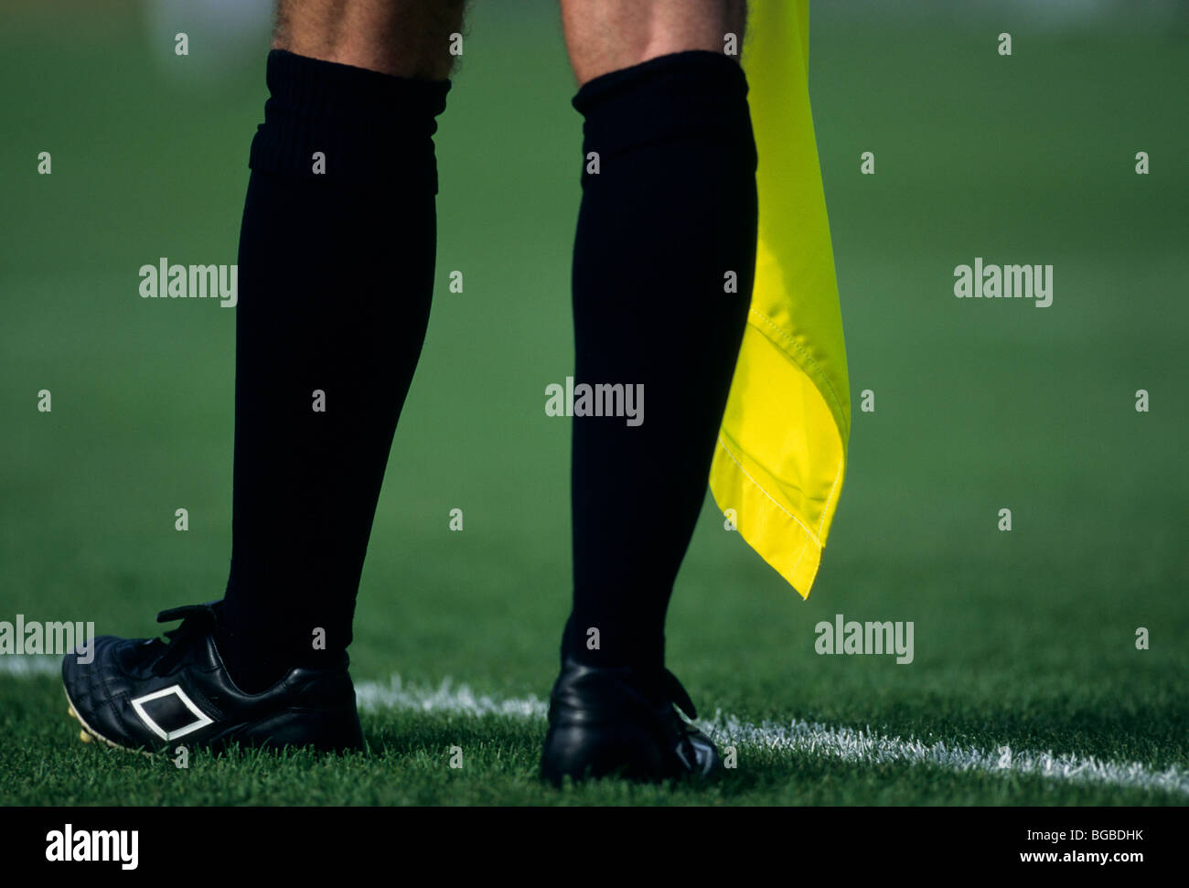 Football referee holding a yellow flag Stock Photo Alamy