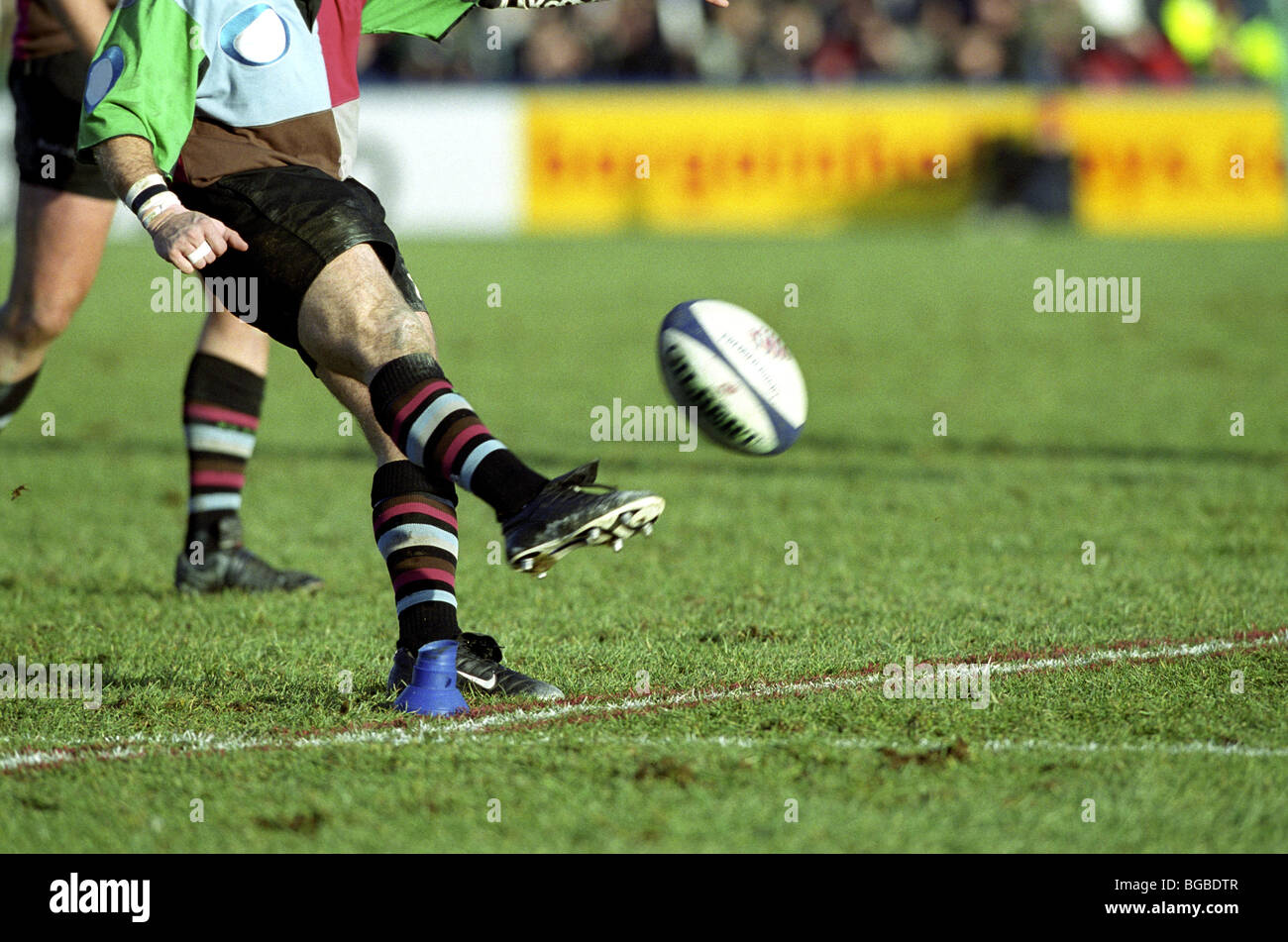 Rugby player kicks the ball off the tee Stock Photo