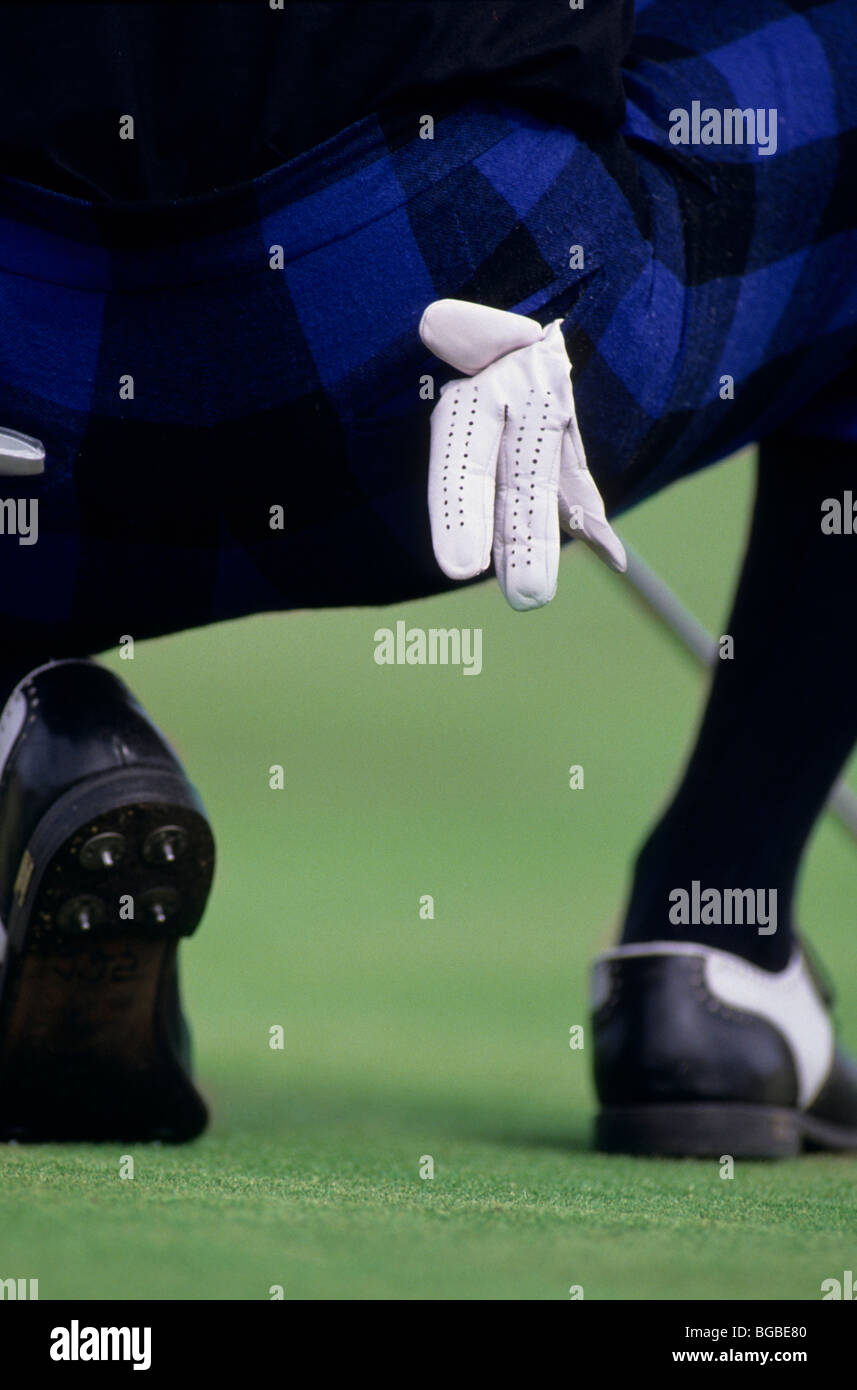 Golfer wearing plus fours crouched down to analyse his shot Stock Photo