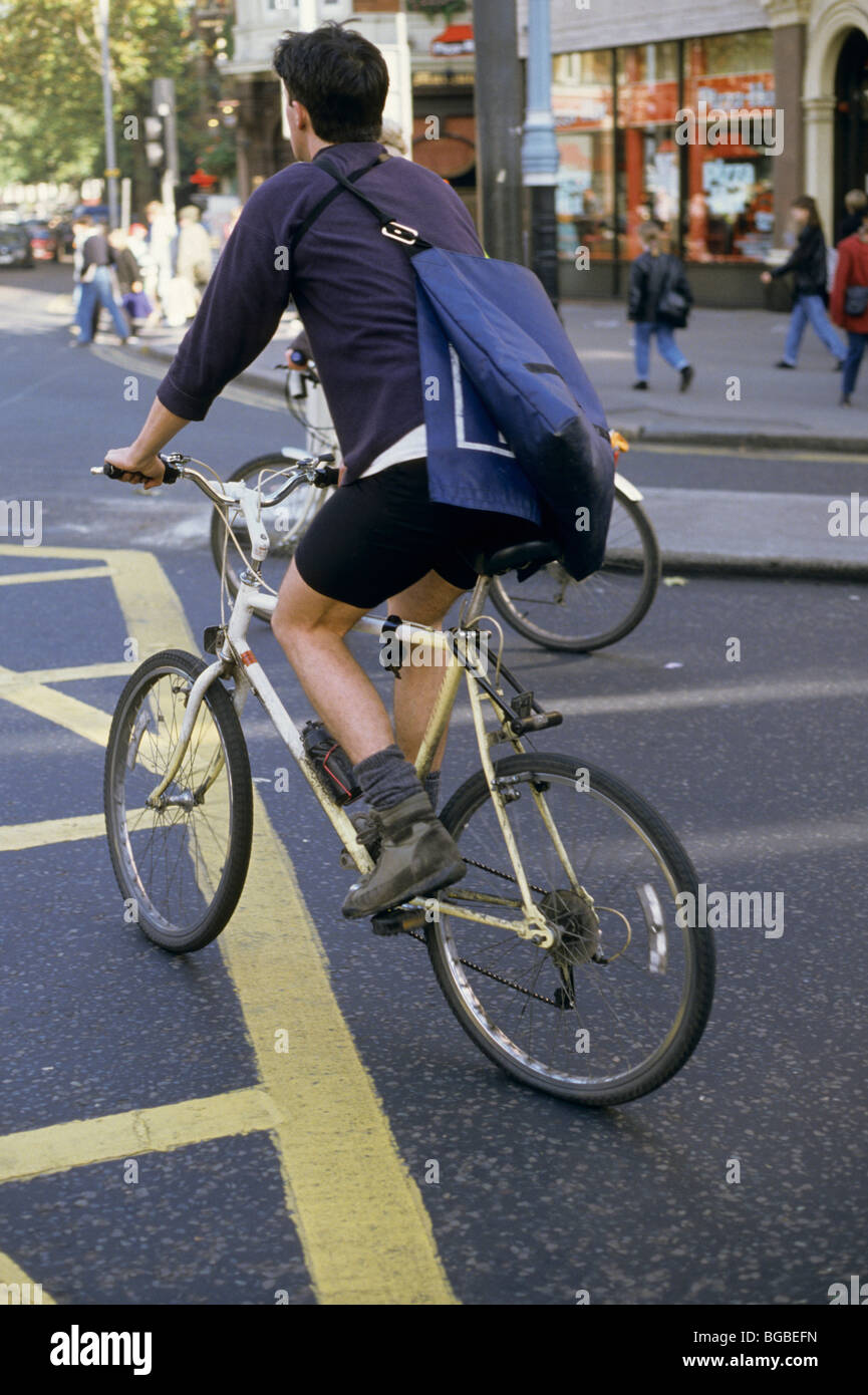 Courier riding a bicycle through an intersection Stock Photo Alamy