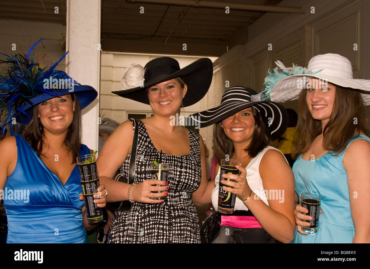 Four friends at Derby Day wearing traditional Derby hats and drinking
