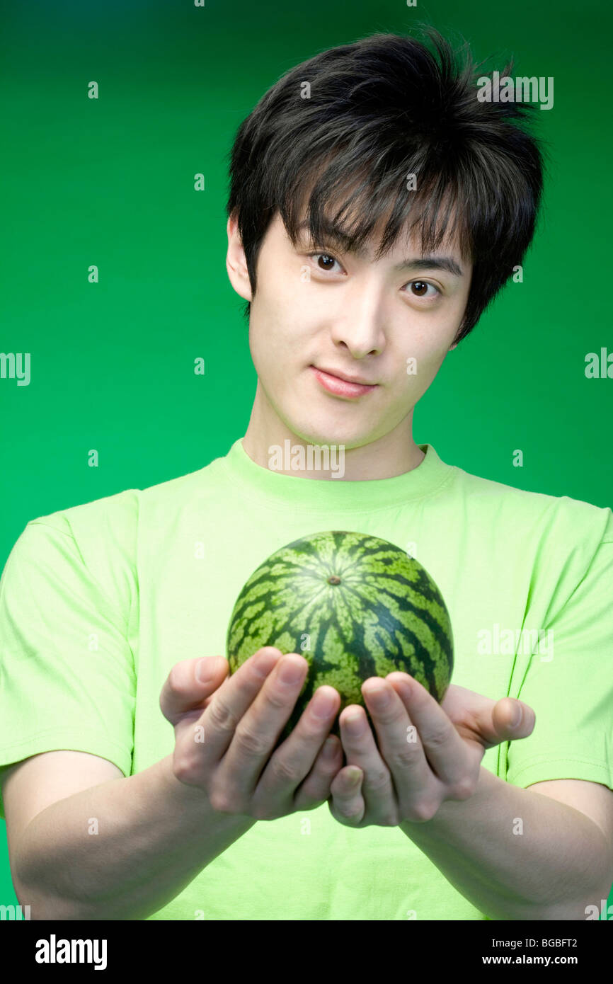Man in green with a melon Stock Photo Alamy