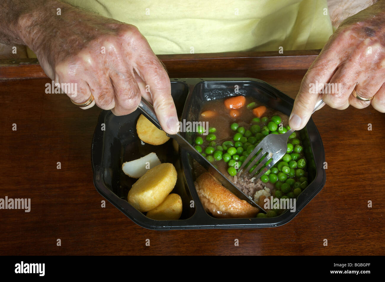 Old age pensioner eating a Birds Eye traditional beef ready meal Stock Photo