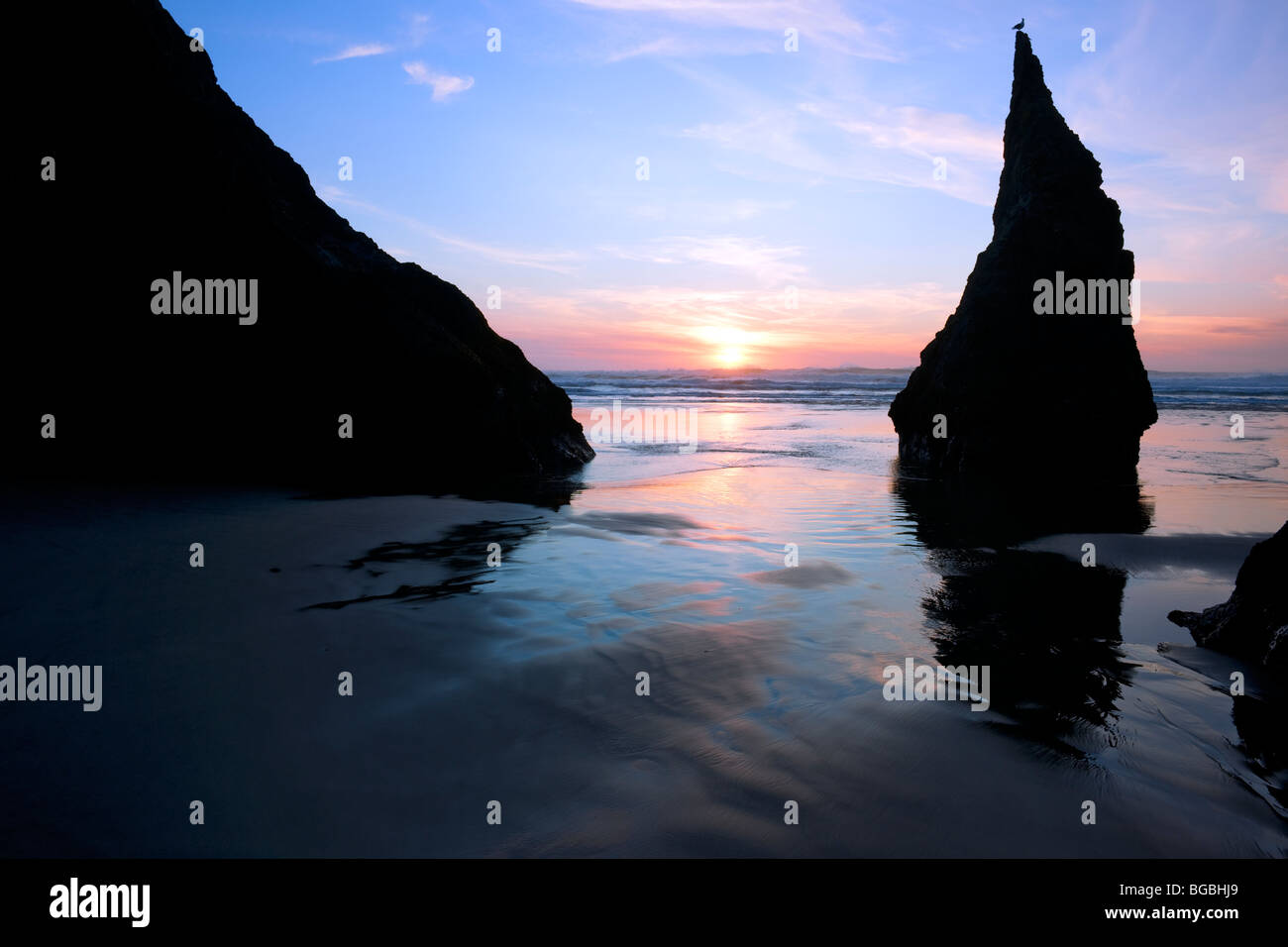 Setting sun silhouettes this sea stack on Oregon's Bandon Beach Stock ...