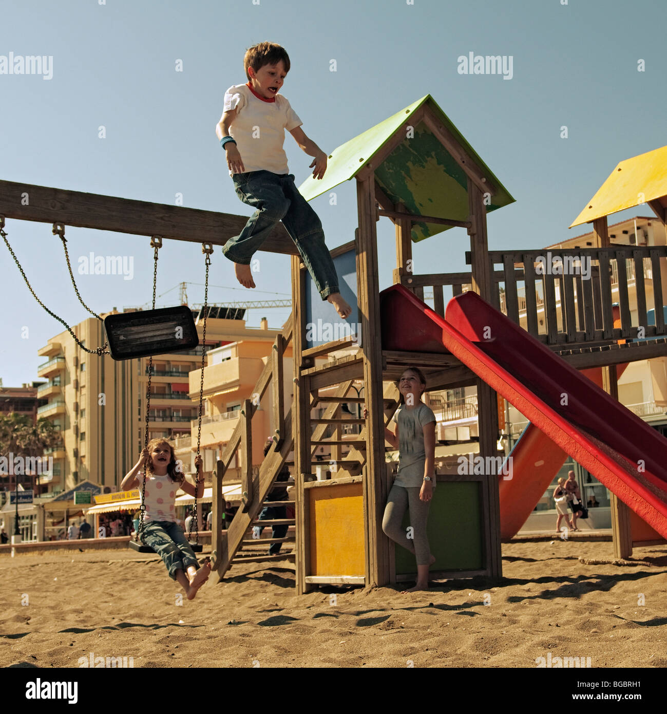 Boy jumping off a swing at the playground Stock Photo Alamy