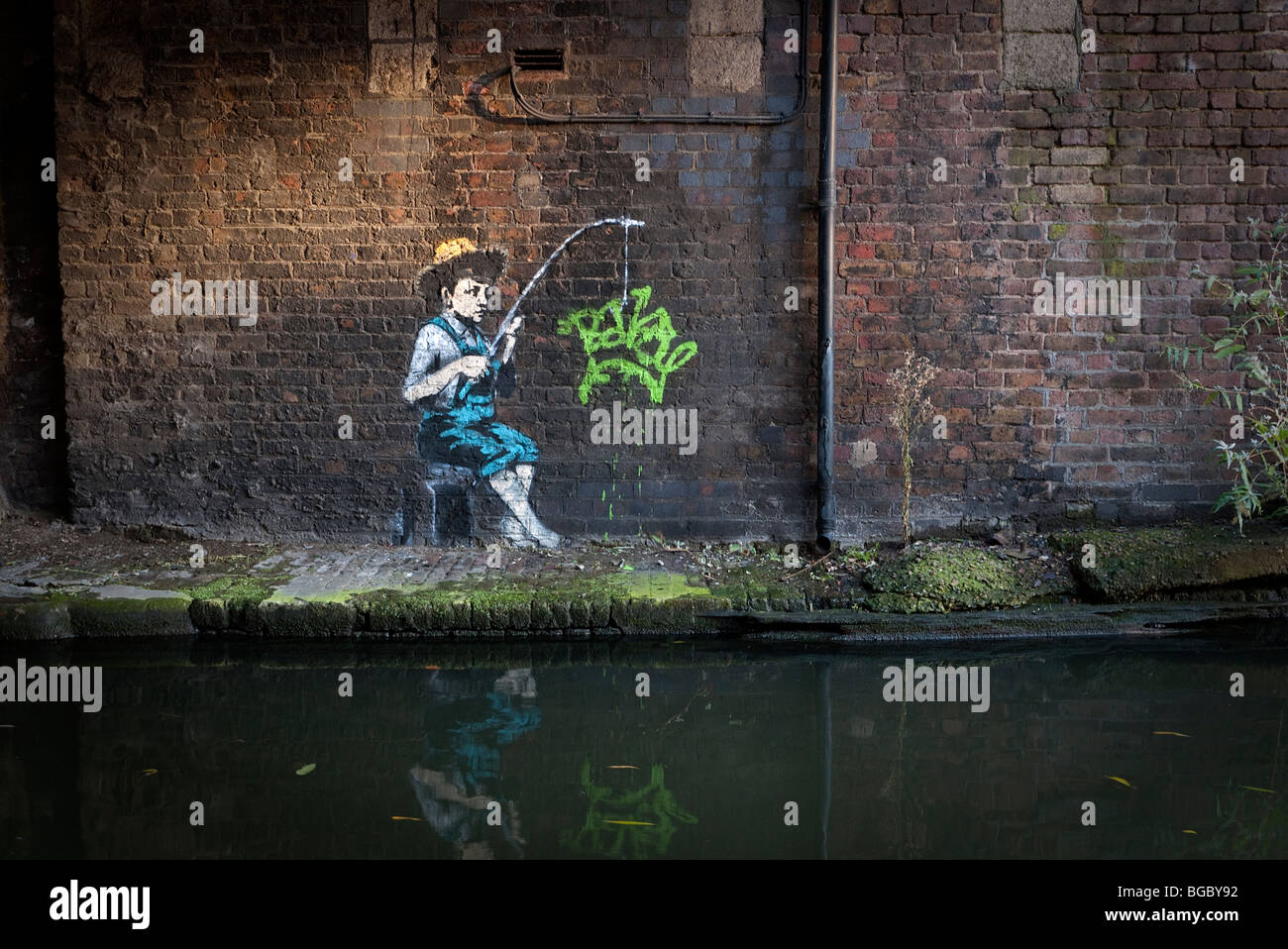 Banksy image of Huckleberry Finn character New graffiti in Camden Lock on Grand Union canal London UK. Stock Photo