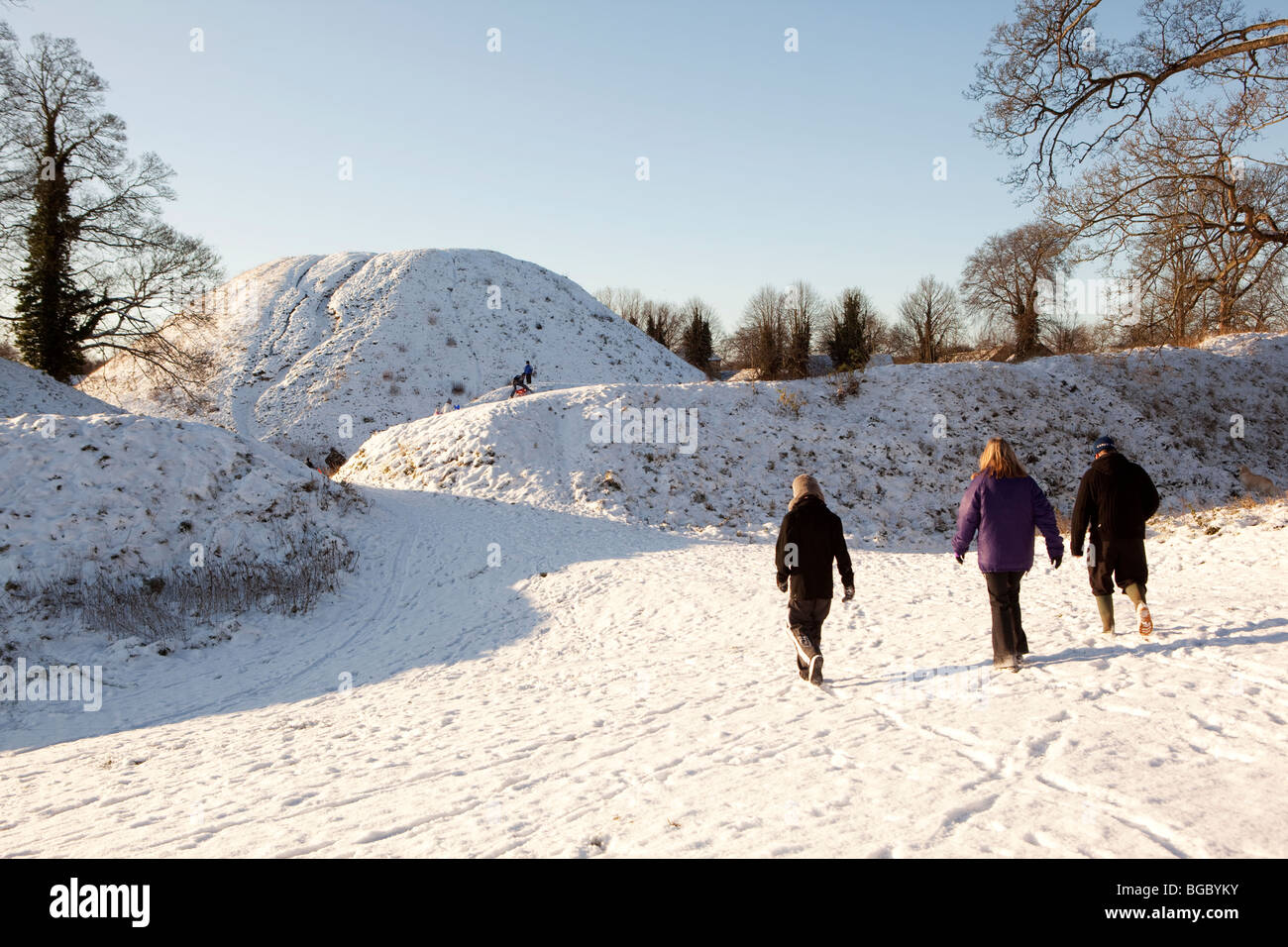 People walking on snow covered Castle Hill, Thetford, Norfolk Stock